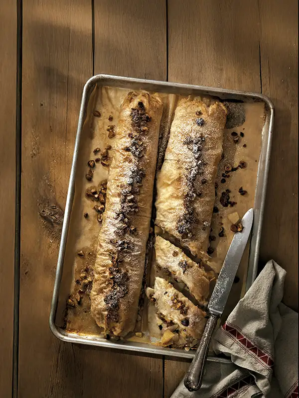 Spiced apple and pear strudel on a wooden table.