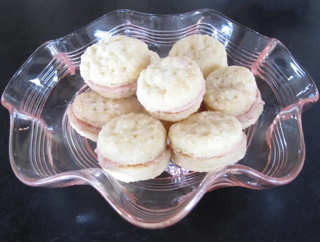 Clear glass dish of cookies on a dark 