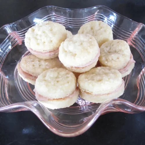 Clear glass dish of cookies on a dark