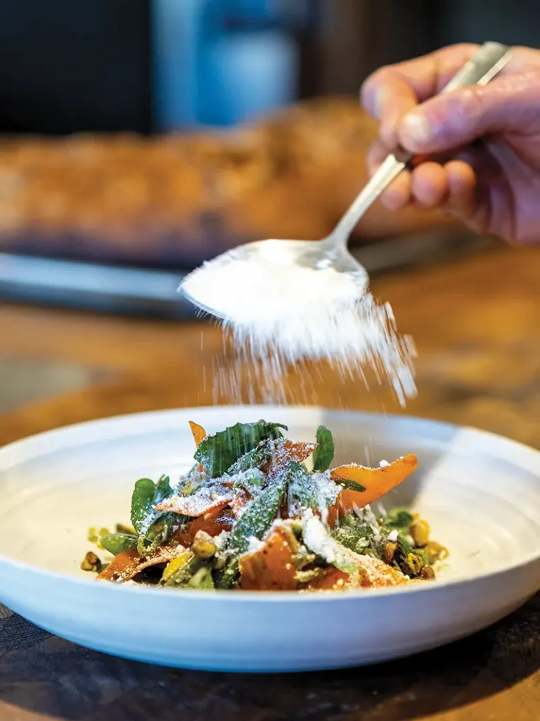 Goat cheese snow rains down on a bowl of Barbareño's Snap Pea and Carrot Salad.