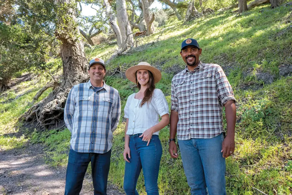 Steve Finkel, Ana Smith and Jesse Smith stand along a trail.