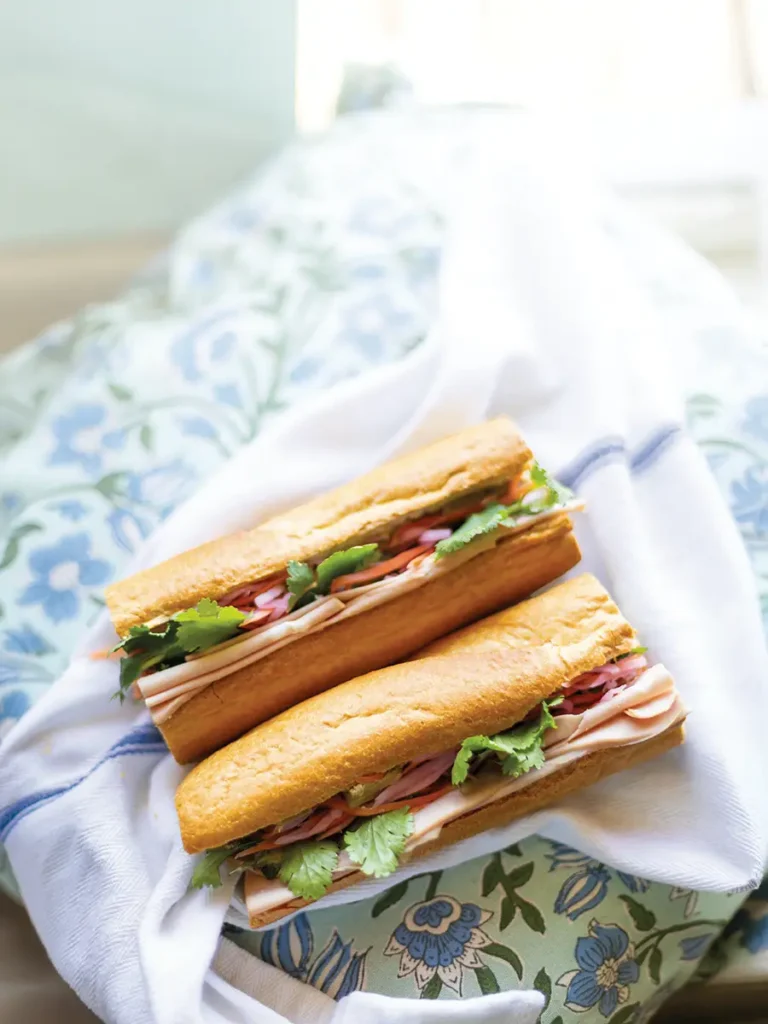 Two halves of a Bánh mì arranged on blue/white linens.