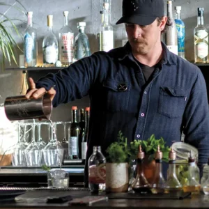 Bartender pouring honeydew milk punch.