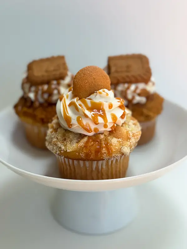Three Tè’Stees Cupcakes on a white pedestal.