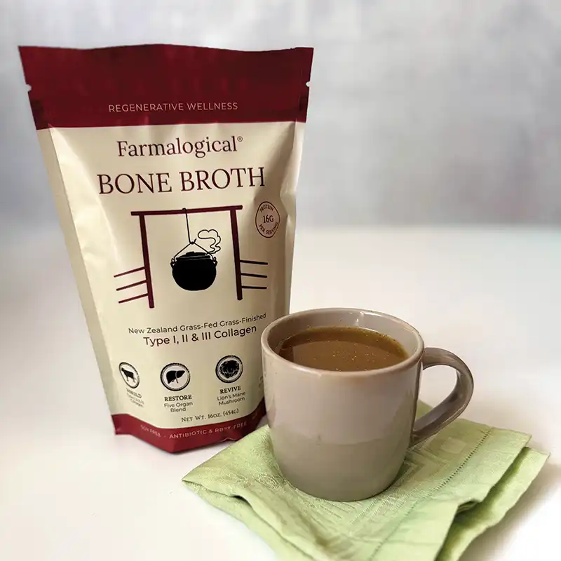 A pouch of Farmalogical’s Bone Broth next to a coffee mug on a napkin.