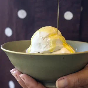Small bowl of ice cream drizzled with olive oil.