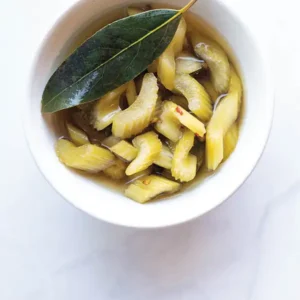 Pickled celery in a white ramekin.