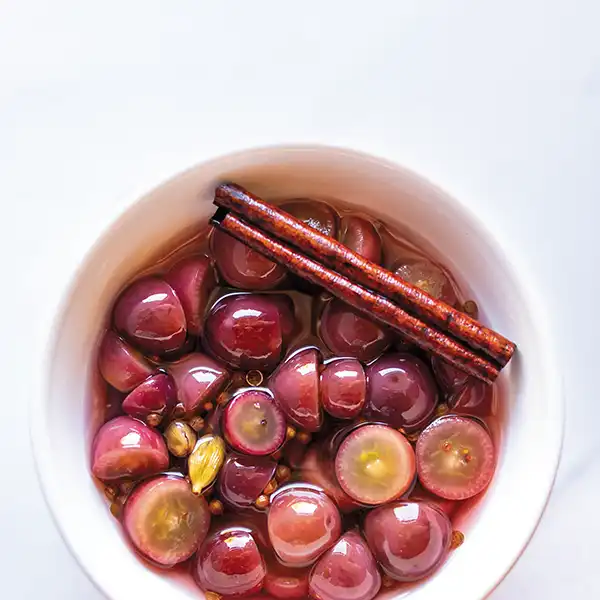 Ramekin full of pickled red grapes.